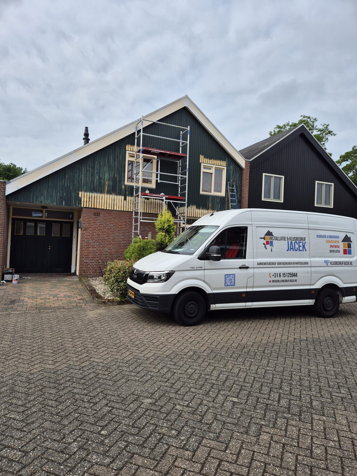 Houten gevelbeschot met steiger tijdens het werk