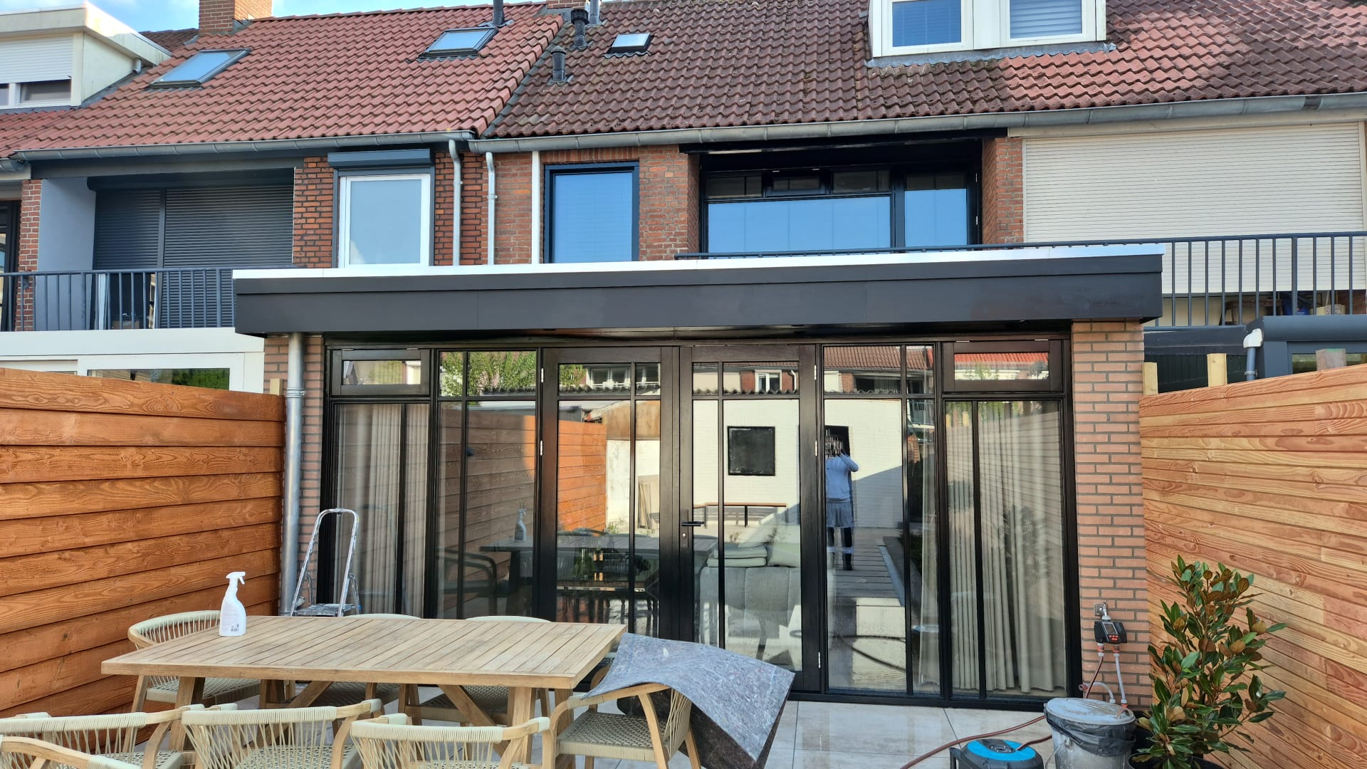 Achtergevel met aanbouw en zwarte vouwpui