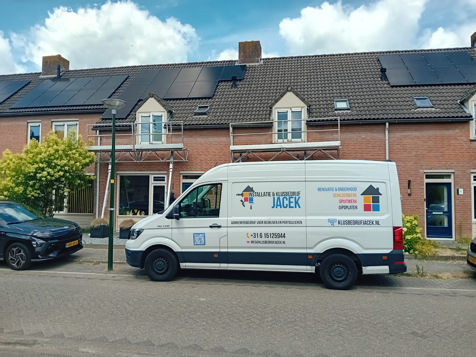 Bedrijfsbus en steiger bij een rijwoning